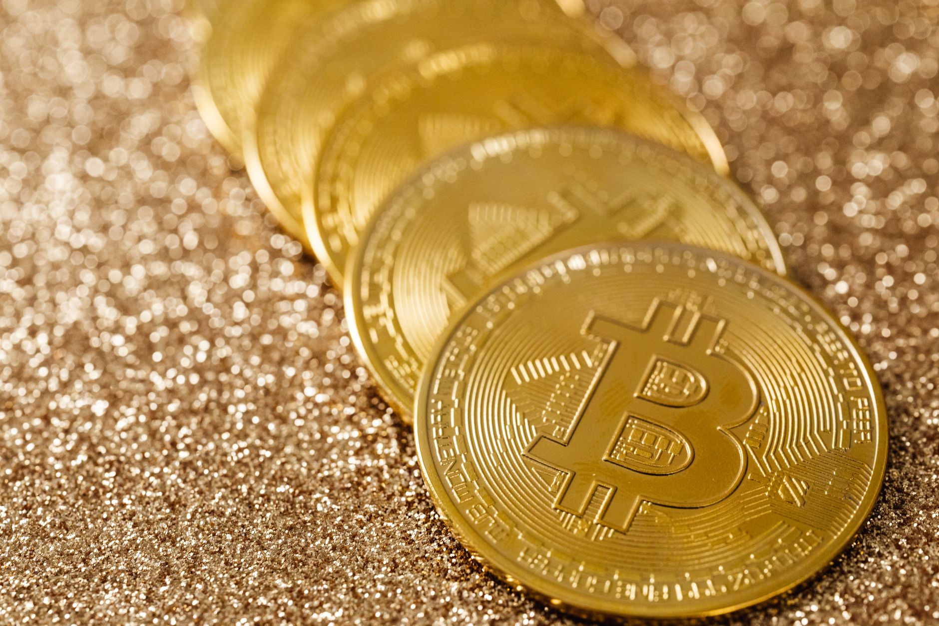 Moedas de bitcoin sobre cédulas de real, ilustrando a volta do bitcoin aos US$ 80 mil e a compra via Pix no Brasil