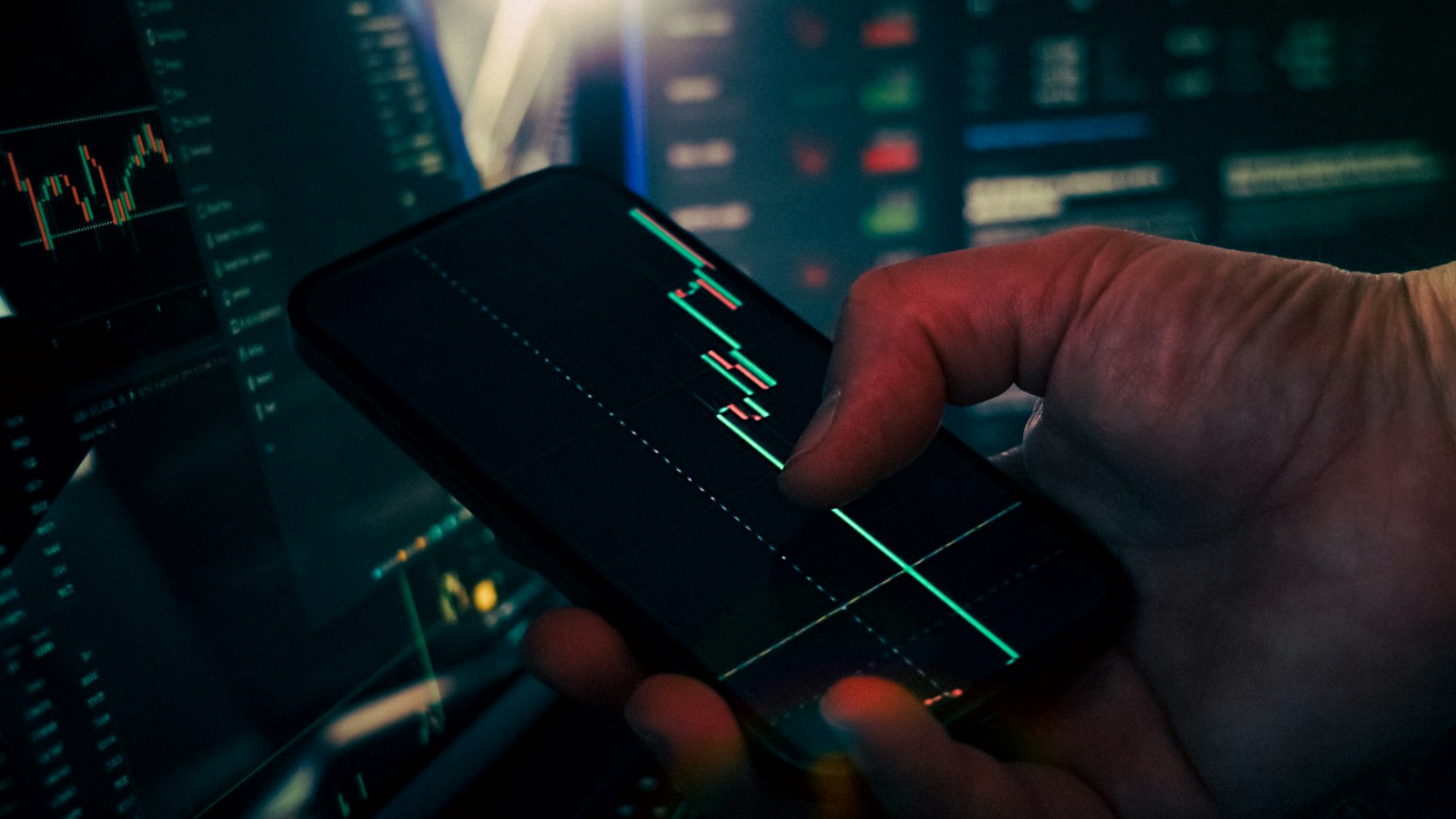 Mão analisando gráficos de mercado de criptomoedas na tela de um celular, representando o investidor brasileiro decidindo o destino dos seus criptoativos durante a consolidação das corretoras no país