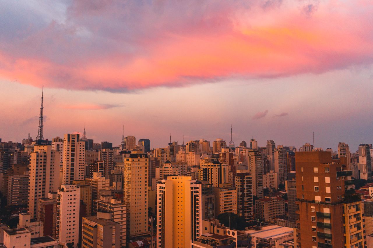 Vista da cidade de São Paulo ao anoitecer, com prédios iluminados, representando a liderança do Brasil na adoção global de criptomoedas em 2026