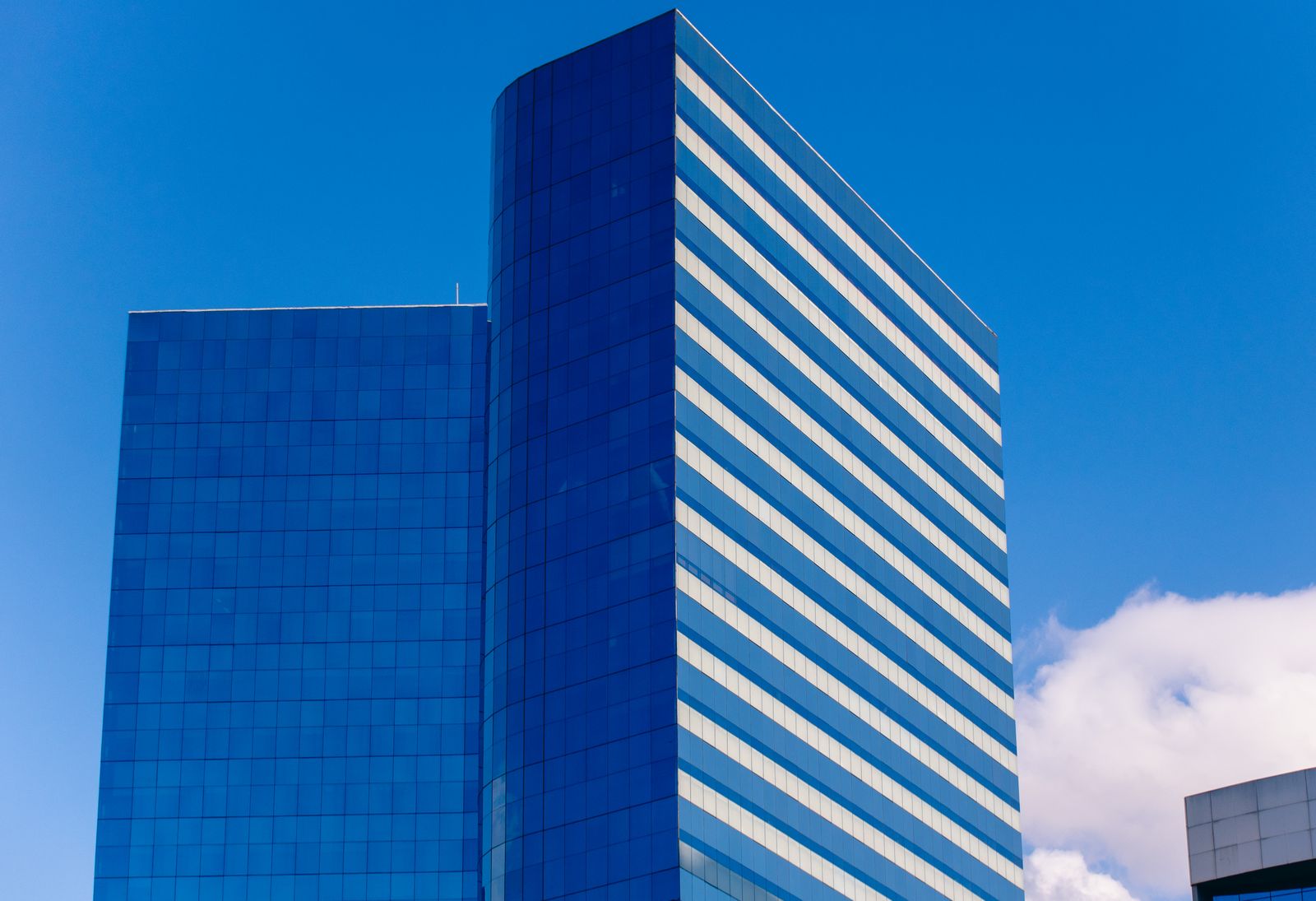 Arranha-céu de vidro em São Paulo sob céu azul, representando o primeiro ETF de renda mensal de tesourarias de Bitcoin listado na B3