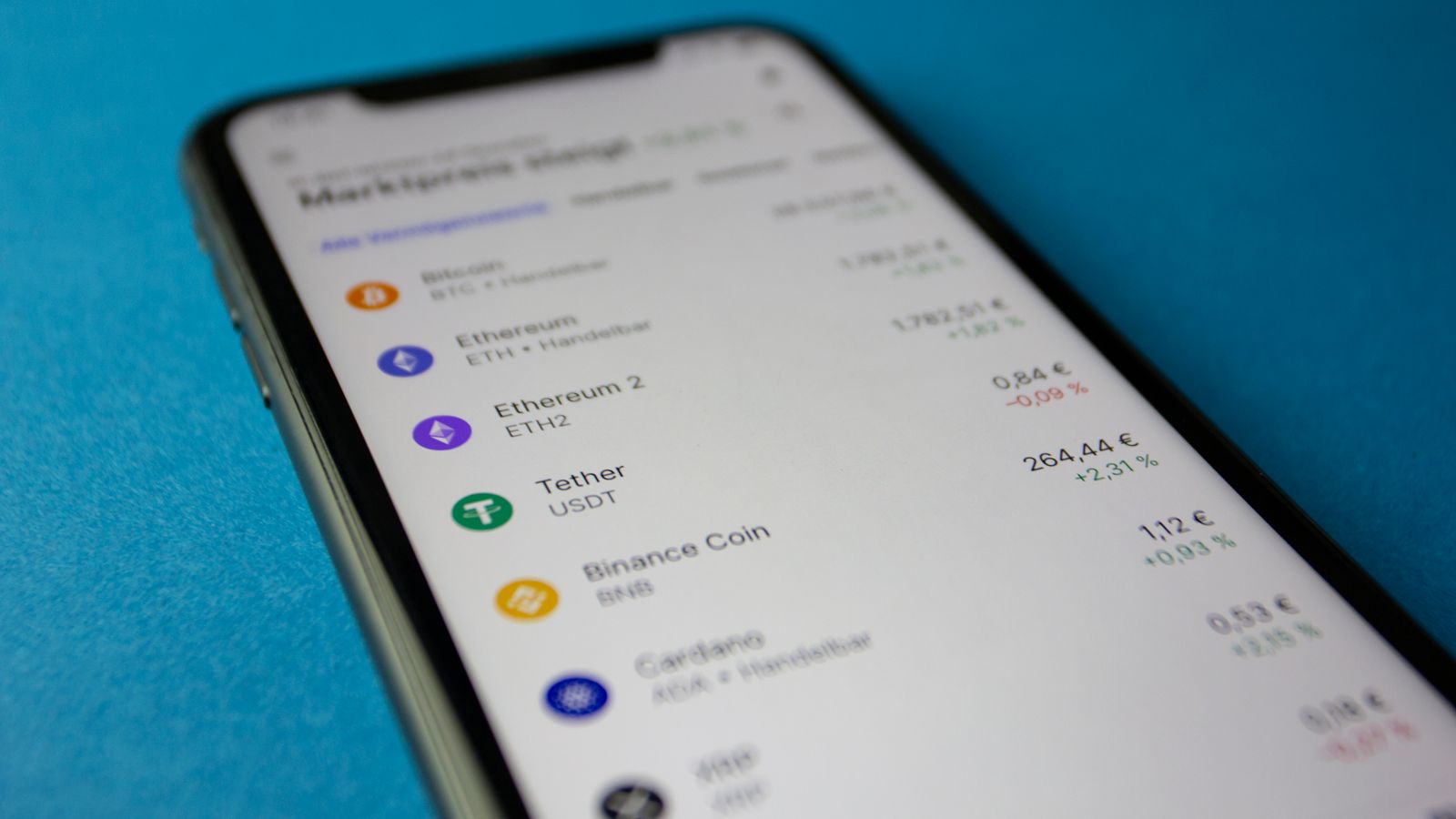 Tela de smartphone em close-up mostrando aplicativo de criptomoedas com gráfico de preços do bitcoin