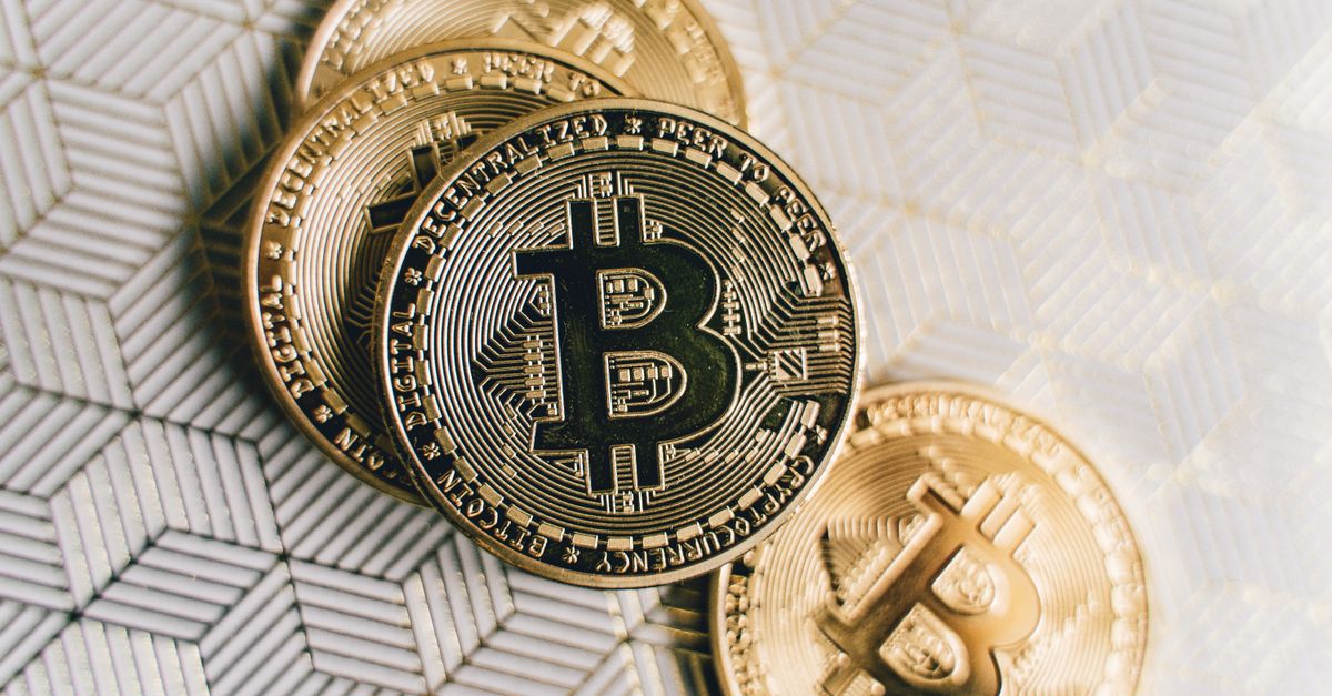 Moedas de bitcoin douradas sobre superfície geométrica, simbolizando a institucionalização do mercado cripto brasileiro com o upgrade do Mercado Bitcoin